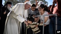 Dečak ljubi ruku pape Franje tokom njegove posete izbegličkom kampu Morija na Lezbosu