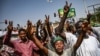 Sudanese protesters chant slogans and flash victory signs as they continue to demonstrate outside the army complex in Khartoum, April 17, 2019. They hardened their demand that the military men in power quickly step down.