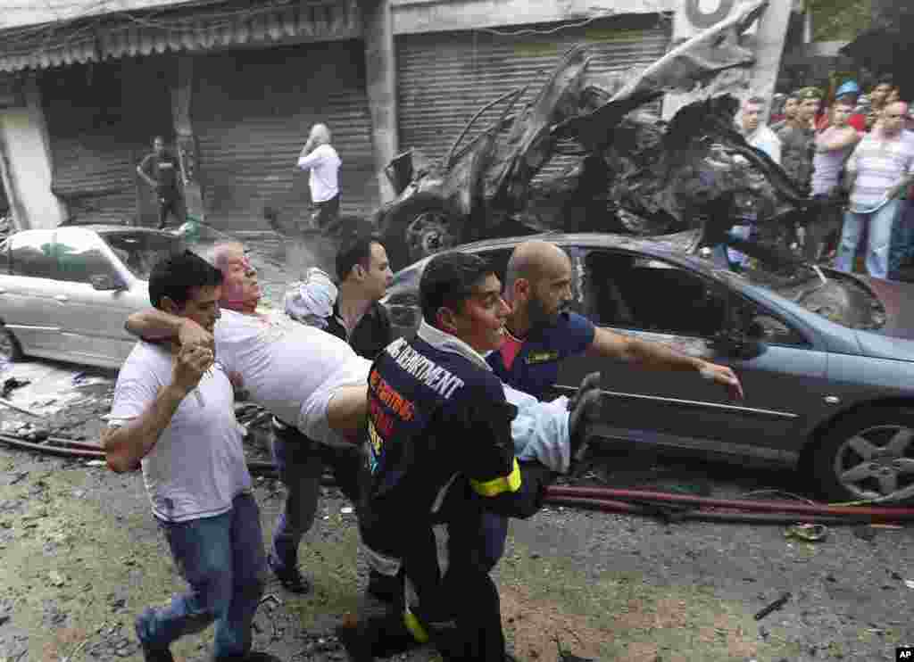 Lebanese rescue workers and civilians carry a wounded man from the scene of an explosion in Beirut, Lebanon, October 19, 2012. 