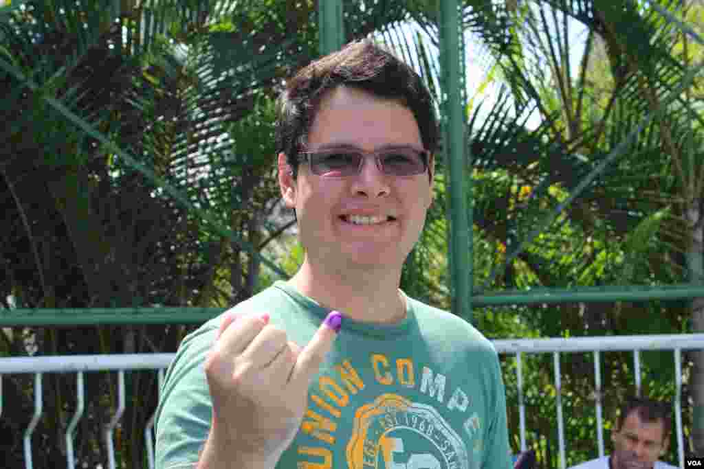 Un joven venezolano en Caracas muestra con orgullo el dedo manchado de tinta como s&iacute;mbolo que ya ejerci&oacute; su derecho al voto. [Foto: Iscar Blanco, VOA]