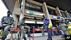 Security contain clients standing outside the headquarters of the Bicici bank as they came to withdraw money in Abidjan, March 3, 2011