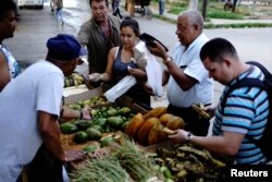 People buy vegetables on a street in Havana, Cuba, Sept. 17, 2018.