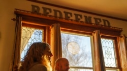 FILE - Jason Wolter, pastor of St. Mark's Lutheran Church, sits next to his wife, Tracy, at their home in Benson, Minn., Nov. 29, 2021.