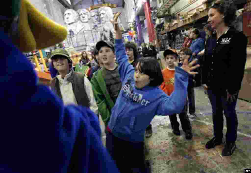 Brian Ray Torres, 11, greets Lewis the Duck during a tour of the Macy's Parade Studio in Hoboken, N.J., Tuesday, Nov. 16, 2010. (AP Photo/Seth Wenig)