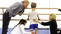 FILE - Artistic director of the School of American Ballet (SAB), Peter Martins (L) and SAB teachers look over an eight-year-old student during the school's 2009 Spring Auditions at Lincoln Center, in New York, May 5, 2009.