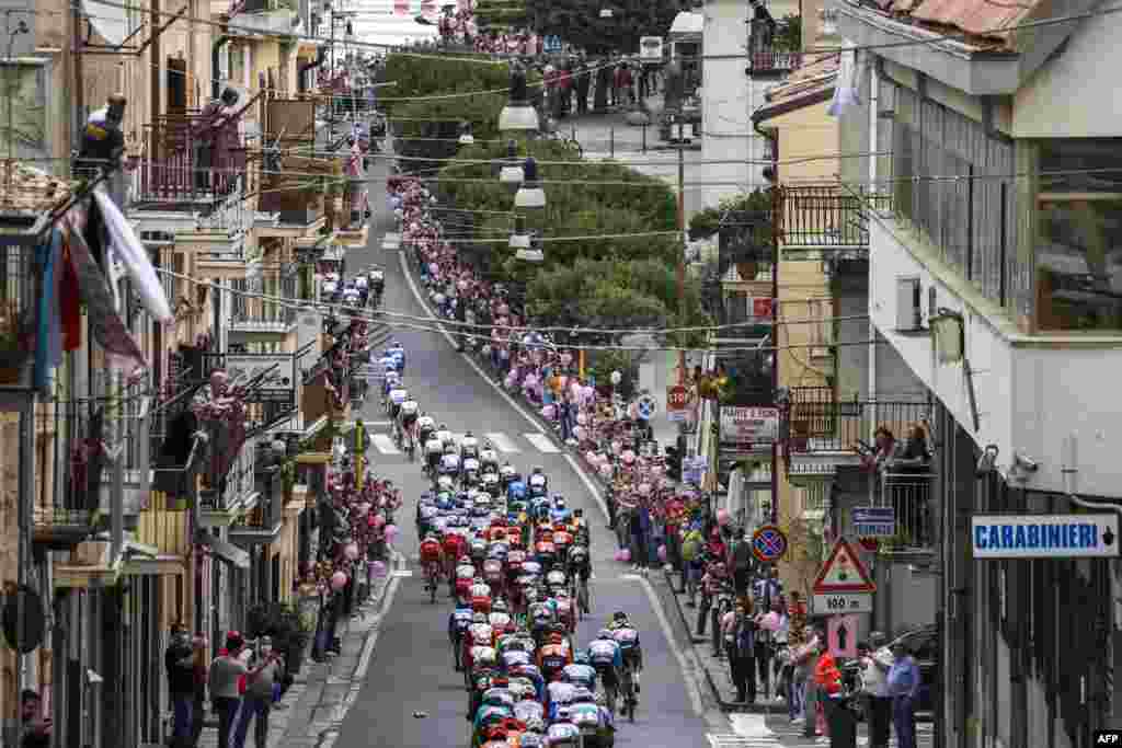 The pack rides through the town of Agira during the 3rd stage of the Giro d'Italia 2020 cycling race, a 150-kilometer route between Enna and volcano Etna, Linguaglossa-Piano Provenzana, Sicily, Italy.