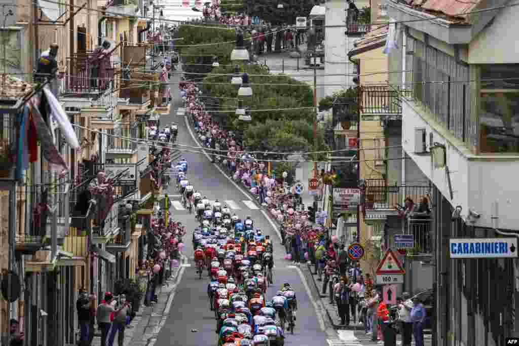 The pack rides through the town of Agira during the 3rd stage of the Giro d&#39;Italia 2020 cycling race, a 150-kilometer route between Enna and volcano Etna, Linguaglossa-Piano Provenzana, Sicily, Italy.