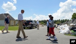 President Barack Obama walks to greet a family to tour their flood-damaged home in the Castle Place neighborhood of Baton Rouge, La., Aug. 23, 2016.