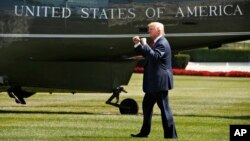 FILE - President Donald Trump gestures to onlookers as he walks on the South Lawn of the White House in Washington, Friday, Aug. 4, 2017, to board the presidential Marine One helicopter.