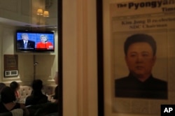 A newspaper front page featuring North Korea former leader Kim Jong II is displayed as people watch live broadcasting of the U.S. presidential debate between Democratic presidential nominee Hillary Clinton and Republican presidential nominee Donald Trump, at Foreign Correspondents' Club in Hong Kong, Sept. 27, 2016.