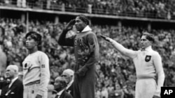 Jesse Owens (tengah) meraih medali emas Olimpiade Musim Panas di Berlin tahun 1936, mengalahkan pelari Jerman Lutz Long (kanan) dan Naaoto Tajima (kiri), 11 Agustus 1936 (Foto: dok). 
