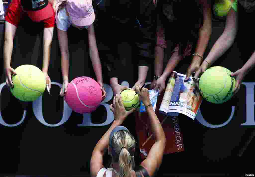 Maria Sharapova of Russia signs autographs after defeating compatriot Olga Puchkova in their women&rsquo;s singles match at the Australian Open tennis tournament in Melbourne. 