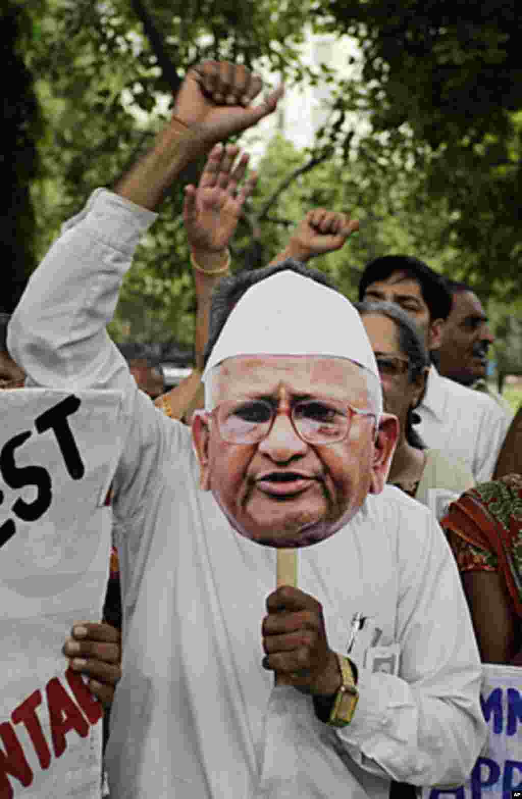 An Indian holds a cut-out of anti-corruption activist Anna Hazare and shouts slogans during a protest in support of Hazare's fight against corruption in Ahmadabad, India, Wednesday, Aug. 17, 2011. Prime Minister Manmohan Singh accused India's most promine