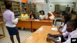 In this file photo, a student reads for U.S. First Lady Michelle Obama during her visit to the all-girls Martin Luther King Middle School, June 27, 2013 in Dakar Senegal. (AP Photo/Carolyn Kaster)