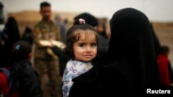 Displaced Iraqis flee their homes on a rainy day as Iraqi forces battle with Islamic State militants, in western Mosul, March 13, 2017.