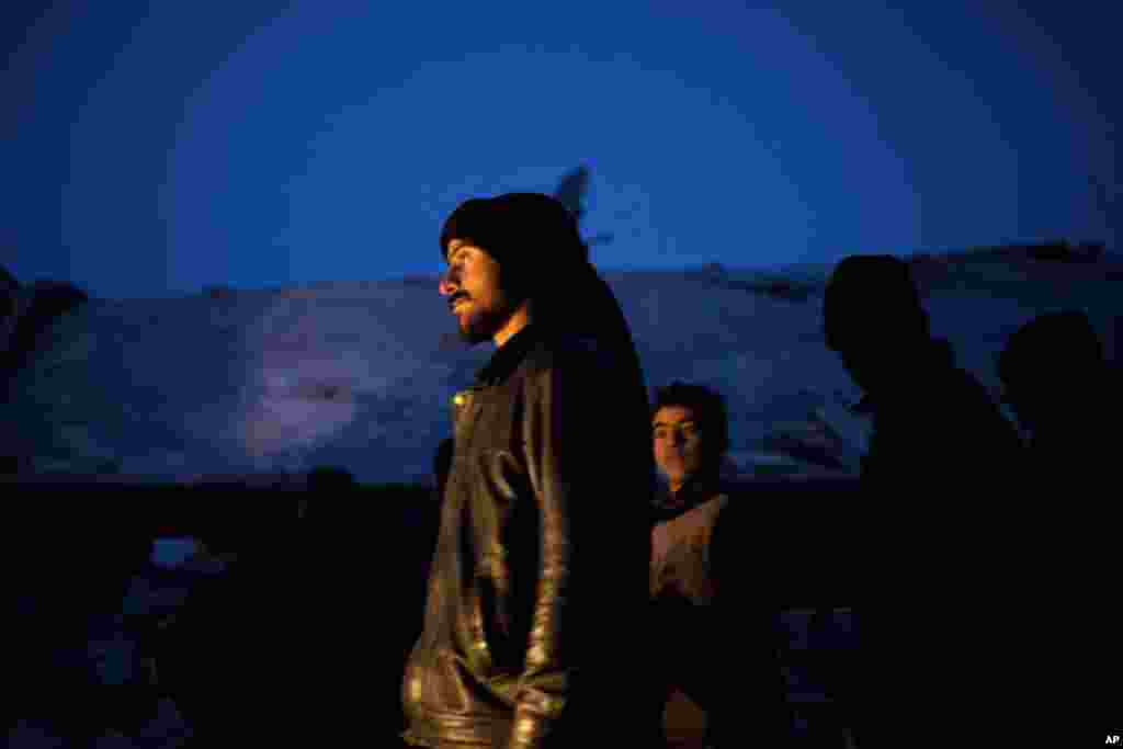 Syrian people seen near a damaged building after it was attacked by a Syrian Army Jet in Azaz, Syria, Sunday, Dec 16, 2012.