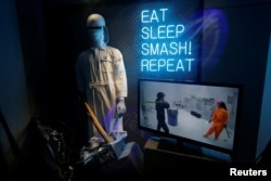 A screen shows a couple with protective gear smashing bottles in a show window at Anger Room 'Smash' in Beijing, China January 12, 2019. Picture taken January 12, 2019. REUTERS/Jason Lee - RC1753FF3920