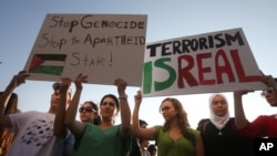 Lebanese and Palestinians hold up placards during a protest against the war in Gaza, in Beirut, Lebanon, July 21, 2014. 