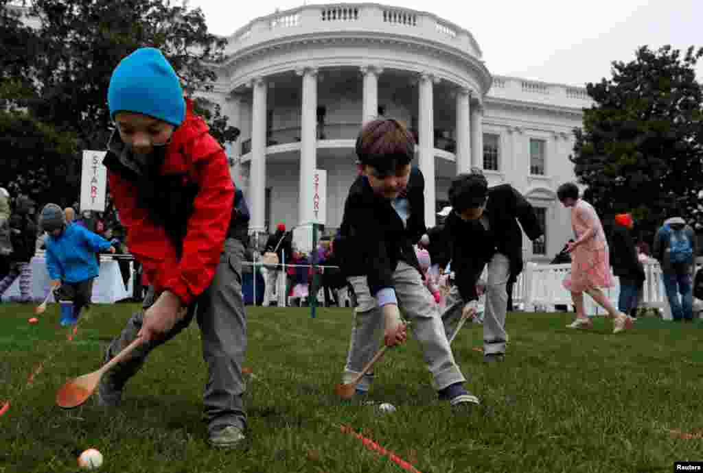 Skye Kennedy (C), 5, Seamus Menefee (L), 7, and Jack Kennedy, 8, participate in the egg roll during the annual White House Easter Egg Roll, April 2, 2018.