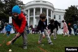 Skye Kennedy (C), 5, Seamus Menefee (L), 7, and Jack Kennedy, 8, participate in the egg roll during the annual White House Easter Egg Roll on the South Lawn of the White House in Washington, April 2, 2018.