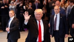  President-elect Donald Trump waves to the crowd as he leaves The New York Times building following a meeting, Nov. 22, 2016, in New York.