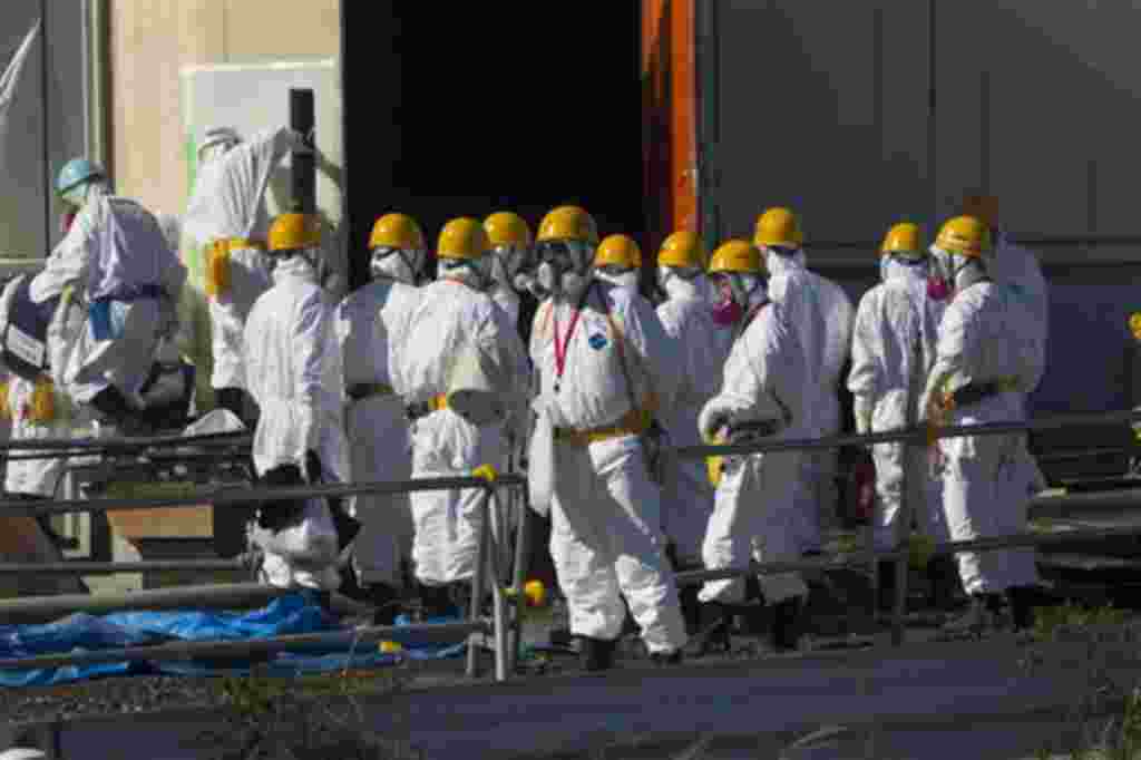 Trabajadores protegidos por sus uniformes y máscaras continúan su trabajo mientras la prensa visita las áreas de la planta de Fukushima, hasta ahora restringidas.