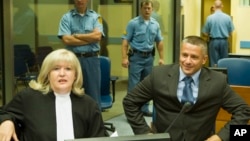 FILE- Naser Oric (R) is seen with his lawyer during his trial in The Hague, Netherlands, July 3, 2008.