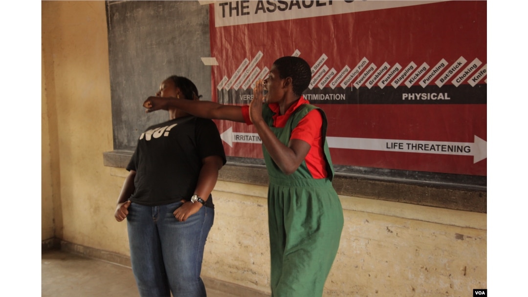 A learner at Ngolowindo primary school in Salima district practices how to disable the potential attacker when she is cornered. (L. Masina/VOA)