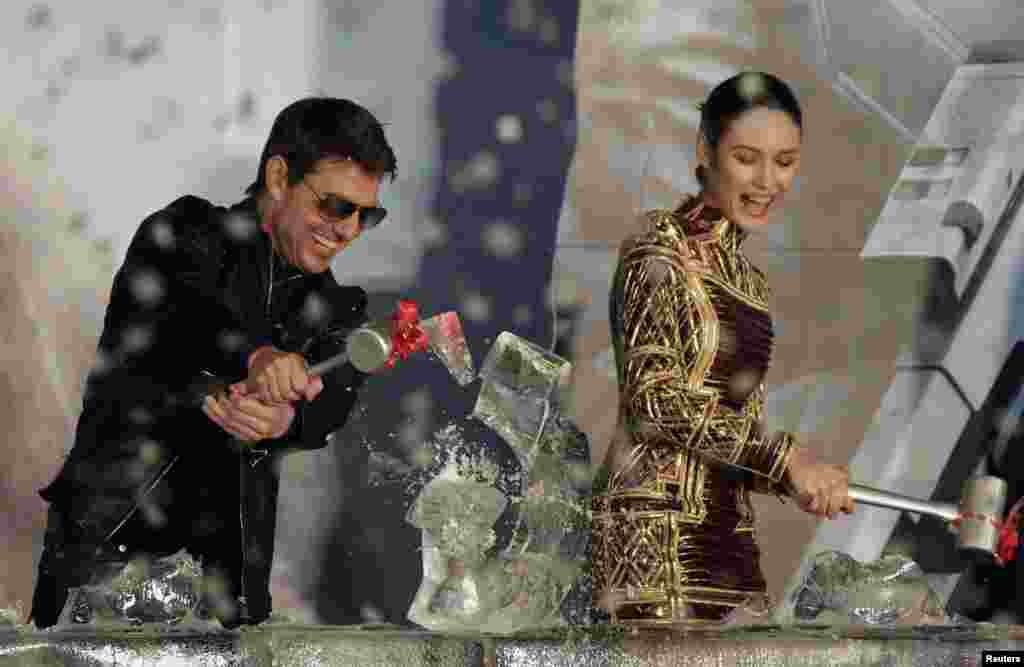 U.S. actor Tom Cruise and Ukrainian-born actress Olga Kurylenko break an ice sculpture during the premiere of their latest movie &quot;Oblivion&quot; in Taipei, Taiwan.