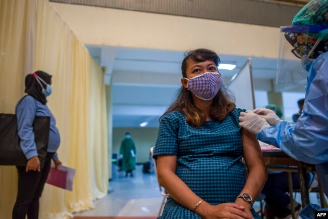 Seorang ibu hamil menerima vaksin COVID-19 Sinovac di Surabaya, 19 Agustus 2021. (Foto: JUNI KRISWANTO/AFP)