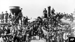 In this May 10, 1869 file photo, railroad officials and employees celebrate the completion of the first railroad transcontinental link in Prementory, Utah. (AP Photo/Union Pacific/Andrew Russell)