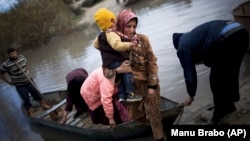 지난 2012년 12월 한 시리아 난민 여성이 자녀를 데리고 오로테스 강을 건너 터키로 피난했다. 