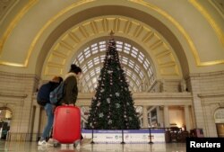 Holiday week train passengers walk by a Christmas tree at Union Station, during the coronavirus disease (COVID-19) pandemic, in Washington, U.S., December 23, 2020.