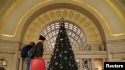 Holiday week train passengers walk by a Christmas tree at Union Station, during the coronavirus disease (COVID-19) pandemic, in Washington, U.S., December 23, 2020