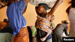 New tech targets small holders in Ghana through radio. Women load sacks of rice onto their heads in the northern Ghana town of Bolgatanga, February 1, 2008. 