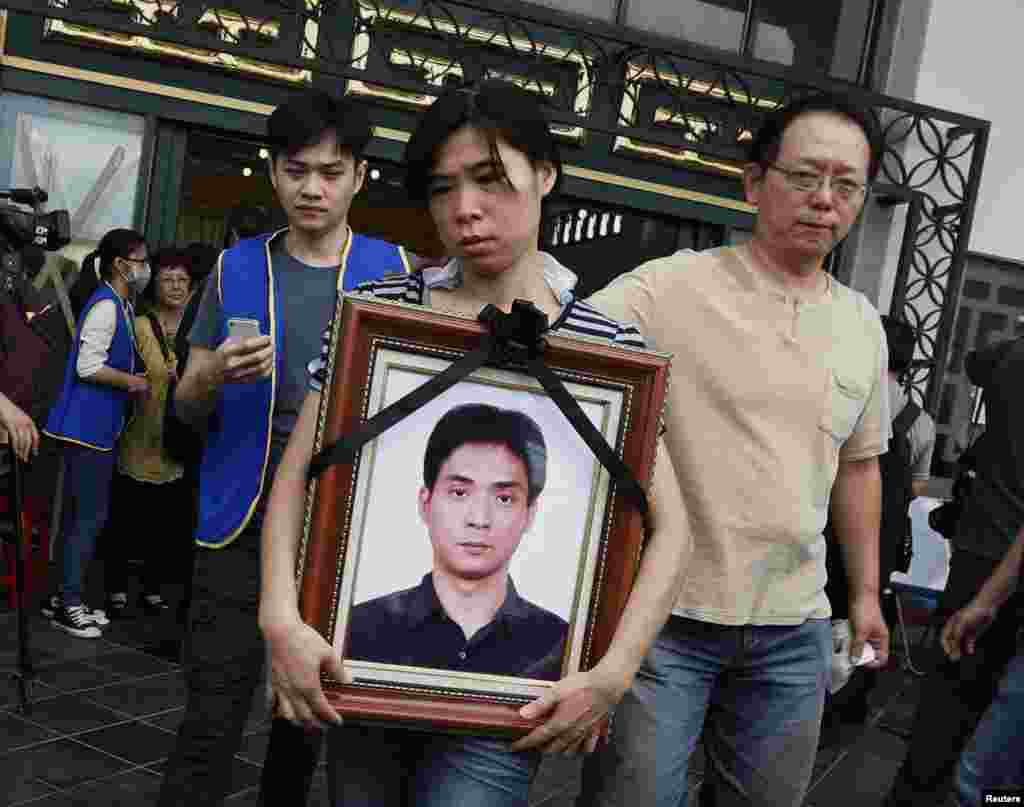 A relative carries a portrait of a passenger who died in a TransAsia Airways plane crash Wednesday, at a funeral home on Taiwan's offshore island of Penghu.