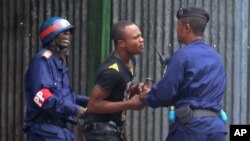 Des policiers arrètent un manifestant à Kinshasa, 19 janvier 2015