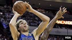 Bintang Dallas Mavericks Dirk Nowitzki (41) berusaha melepaskan tembakan sementara dihadang pemain Miami Heat Udonis Haslem (40) dalam pertandingan kedua final NBA Kamis (2/6) di Miami.