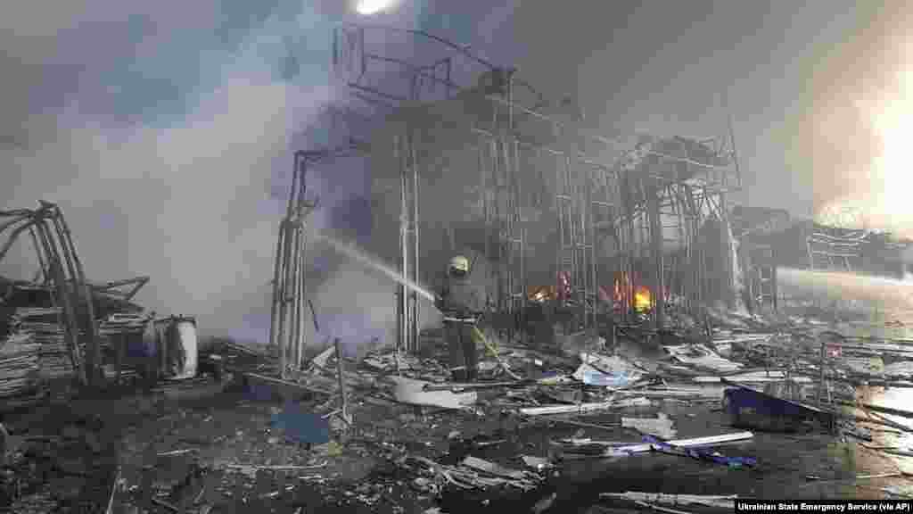 Firefighters work to extinguish a fire at a market hit by shelling in Kharkiv, Ukraine, March 16, 2022. 