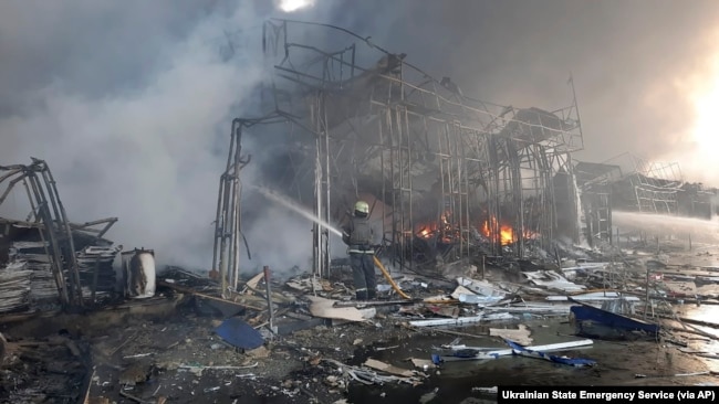 In this photo released by the Ukrainian State Emergency Service press service, firefighters work to extinguish a fire at a market hit by shelling in Kharkiv, Ukraine, Wednesday, March 16, 2022. (Ukrainian State Emergency Service via AP)