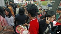 A worker carries a plate of food to be delivered to a customer at a food court in Jakarta January 28, 2011. Indonesia will suspend import duties on rice, soybeans and wheat as part of government efforts to fight inflation and the president warned about th
