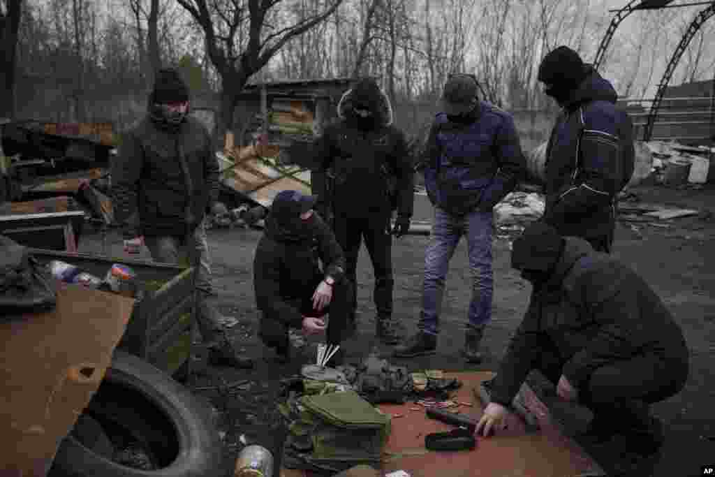 Roman, a former Ukrainian soldier injured in combat, center, gives instructions on how to handle weapons and move in the outskirts of Lviv, west Ukraine, March 3, 2022.