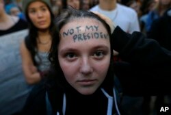 Clair Sheehan has the words "Not My President" written on her forehead as she takes part in a protest against the election of President-elect Donald Trump, Nov. 9, 2016, in downtown Seattle.
