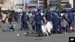 FILE: Riot police arrest and forcibly apprehend protestors during protests in Harare, Friday, Aug, 16, 2019. 