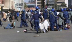 FILE: Riot police arrest and forcibly apprehend protestors during protests in Harare, Friday, Aug, 16, 2019.