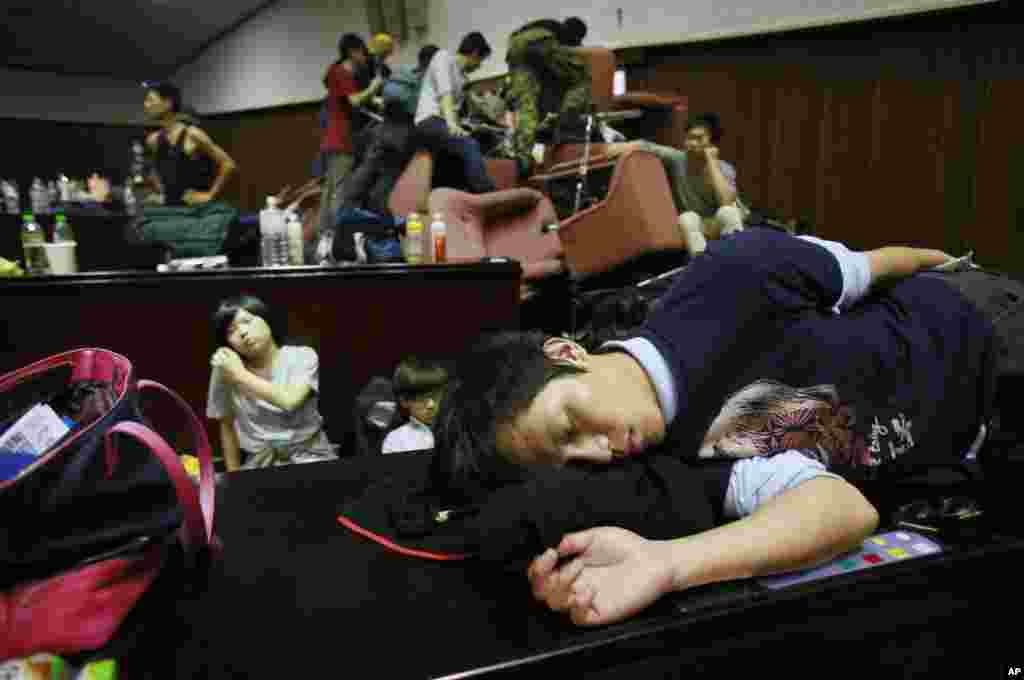 Seorang siswa demonstran tidur di atas lantai parlemen setelah bersitegang dengan polisi di Taipei, 19 Maret 2014.