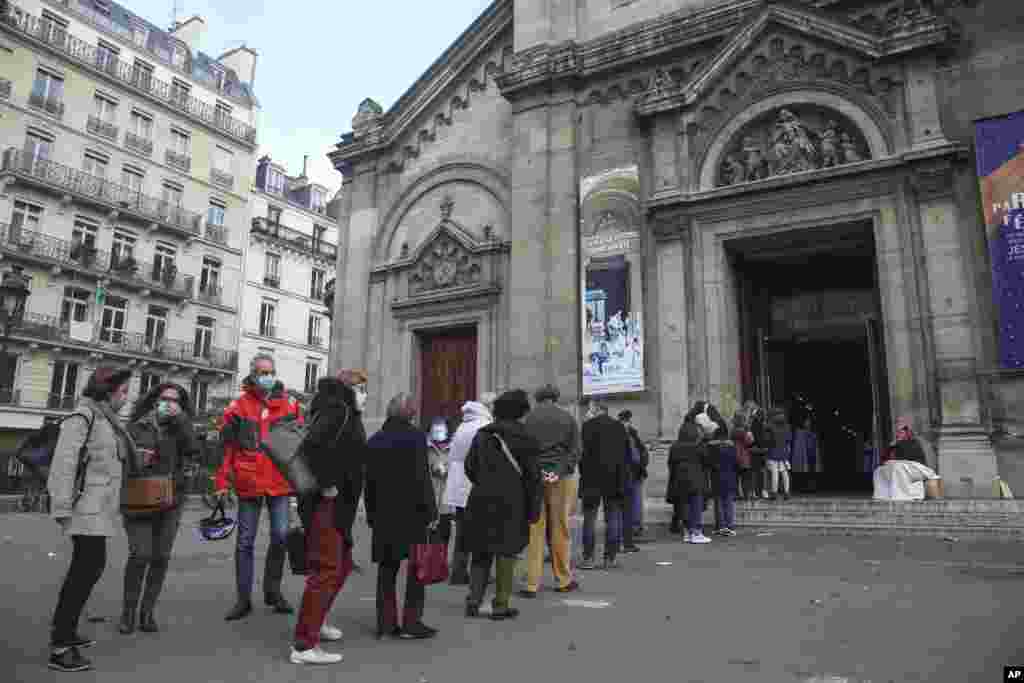 Church-goers wearing face masks lineup outside the Notre-Dame-des-Champs church in Paris, France. Churches, mosques and synagogues can open their doors again to worshippers as France cautiously starts reopening after a second virus lockdown.