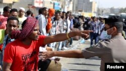 An Ethiopian worker argues with a member of the Saudi security forces.