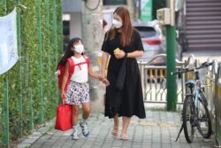 Seorang ibu mengantar anaknya berangkat ke sekolah di Seoul, Korea Selatan, 25 Agustus 2020.