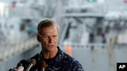 Vice Adm. Joseph Aucoin, commander of the U.S. 7th Fleet, speaks during a press conference, with the damaged USS Fitzgerald in the background at the U.S. Naval base in Yokosuka, southwest of Tokyo, June 18, 2017.